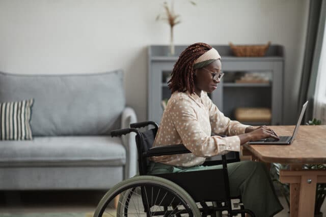 african american woman in wheelchair using computer